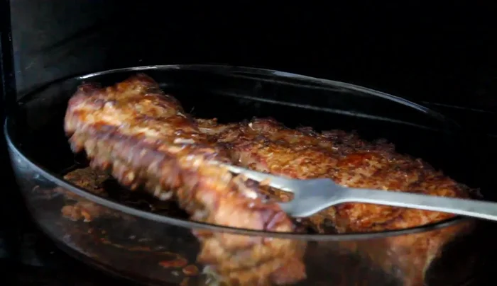 Enfourner les travers de porc pendant 50 minutes, en les retournant à mi-cuisson.