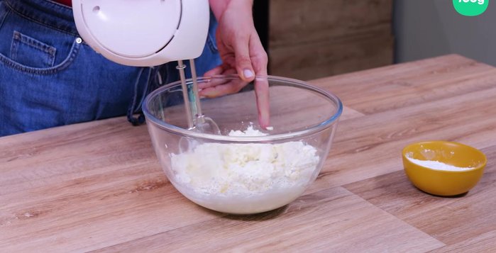 Mélangez au batteur électrique le fromage frais, le mascarpone et le sucre glace progressivement jusqu'à obtenir une consistance lisse. Ajoutez le zeste d'orange et la crème liquide, puis mélangez.