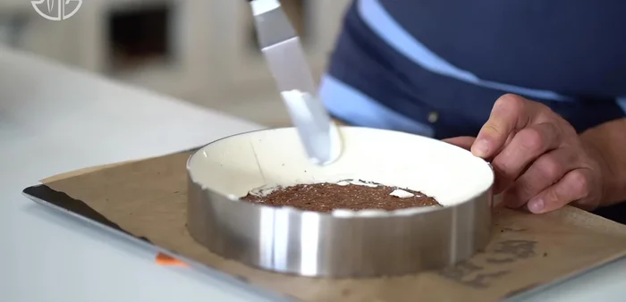Montage du cheesecake : Déposer deux cordons épais de garniture au fromage à la crème le long des bords du cercle à gâteau. Étaler contre les côtés. Remplir le gâteau au tiers et garnir de boules de gelée de fraise. Recouvrir avec le reste de la garniture et lisser. Placer au congélateur toute la nuit. (250.56)