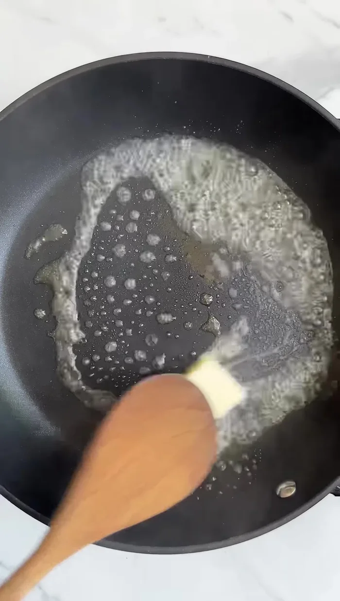 Dans une poêle, faire revenir l'ail avec du beurre. Une fois parfumé, ajouter la crème épaisse et assaisonner avec du sel, du poivre, de la poudre d'oignon et du parmesan. Faire cuire jusqu'à ce que le mélange soit bien épais.