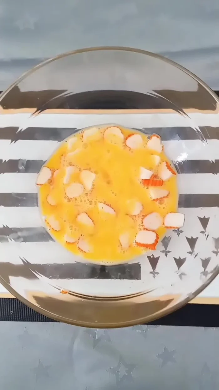 Couper les bâtonnets de crabe en rondelles et les mélanger dans un saladier avec l’œuf, le fromage blanc, le lait de soja, la maïzena, le sel, le poivre, l'ail en poudre, les herbes, l'échalote en poudre et le curry.