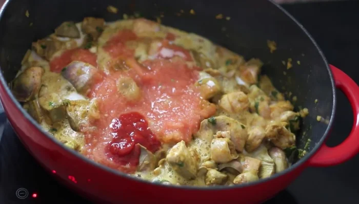 Rajouter de la tomate râpée, du concentré de tomate et un peu d'eau. Couvrir et laisser mijoter, en ajoutant de l'eau si nécessaire.