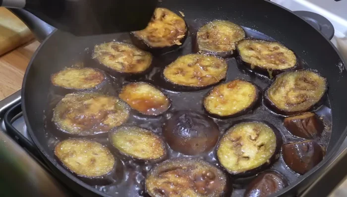 Continuer la cuisson des aubergines en retournant toutes les minutes jusqu'à ce que la sauce soit réduite (5 à 6 minutes).