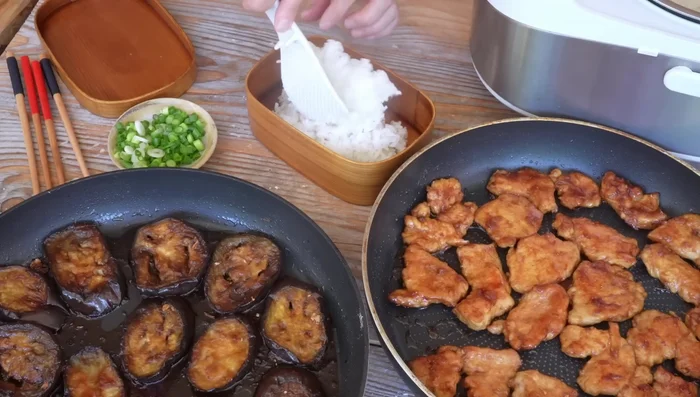 Servir le poulet et les aubergines avec du riz rond. Parsemer de ciboulette, de graines de sésame grillé, de sauce crémée, de gingembre au vinaigre (gari) et de chili en poudre (shichimi).