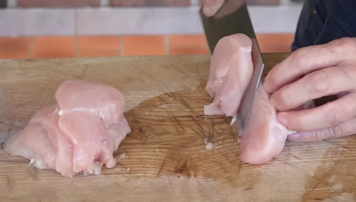 Couper les 2 blancs de poulet en tranches de 1 cm d'épaisseur. Les mettre dans un récipient avec 1 cuillère à soupe de saké, 1/4 de cuillère à café de sel et du poivre. Bien mélanger et laisser reposer.