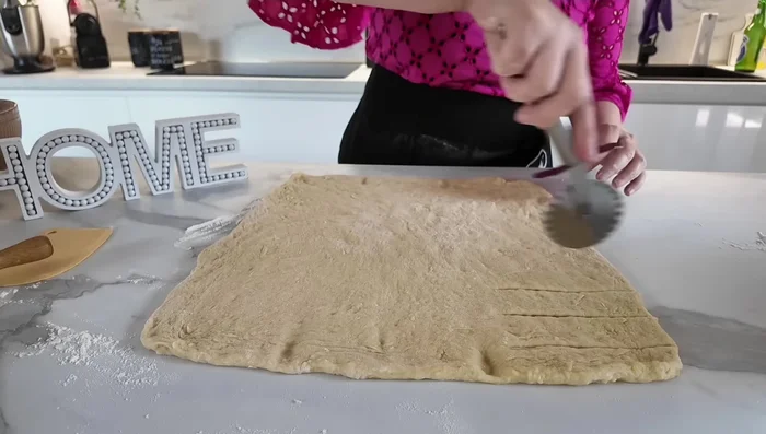 Diviser la pâte en trois parties. Couper des fentes de 2-3 cm sur une des extrémités de la pâte. (198.28)