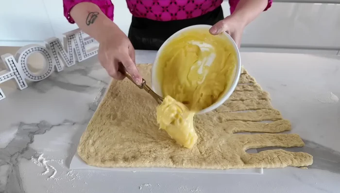 Étaler la crème pâtissière au centre de la pâte. Ajouter les cerises noires au sirop. (209.56)