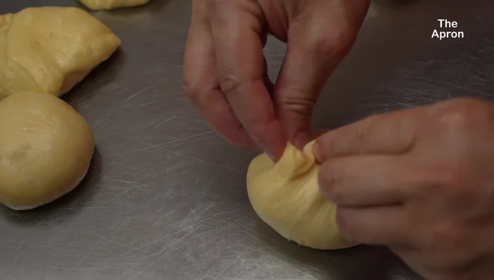 Façonnage : Divisez la pâte en 6 portions égales. Formez des boules et placez-les dans un moule à pain graissé. Laissez lever 45 minutes à 1 heure.