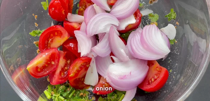 Ajouter les légumes (tomate, oignon, concombre) à la vinaigrette.
