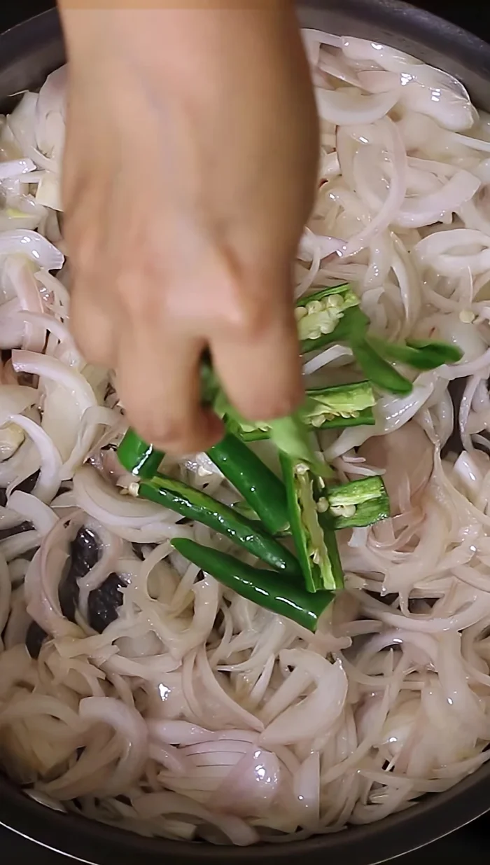 Ajoutez les piments verts coupés et les feuilles de curry fraîches, en remuant jusqu’à ce que les oignons deviennent dorés.