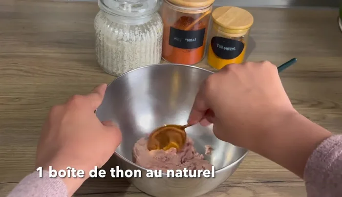Dans un saladier, mélanger une boîte de thon au naturel, un oignon émincé et une tomate émincée.