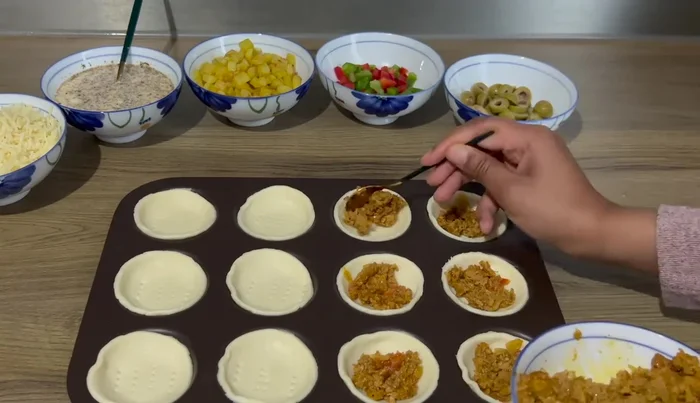 Ajouter une couche de préparation au thon, puis les poivrons, les pommes de terre et les olives.