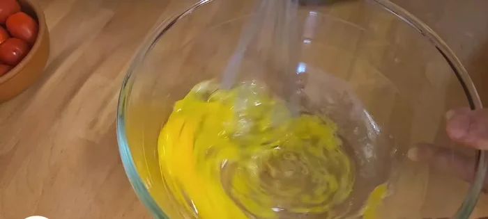 Préparer l'appareil à quiche : Battre les œufs (93.759), ajouter la crème fraîche (105.399) diluée avec un peu de lait (117.439), puis le sel (155.72), les herbes de Provence (158.12) et le poivre (164.04).