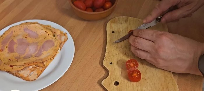 Couper les tomates cerises en deux (181.44) et les répartir dans le fond de tarte (191.08).