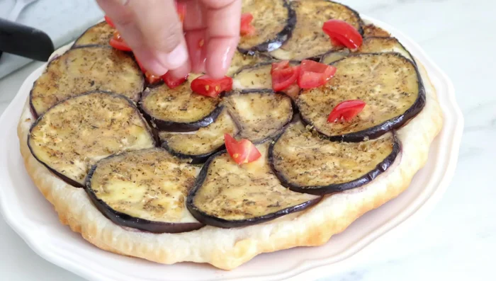 Décorer avec des tomates fraîches, des herbes de Provence (ou basilic) et des amandes concassées (facultatif).