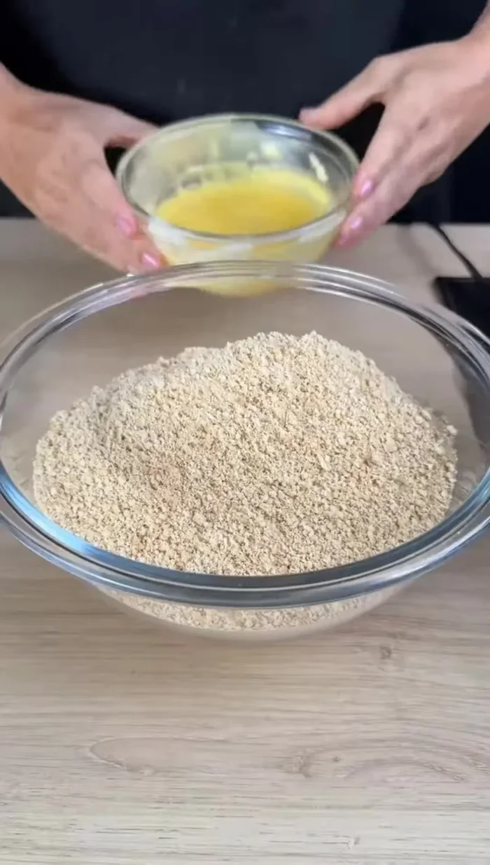 Mélanger les biscuits moulus avec 150g de beurre fondu jusqu'à obtenir une pâte homogène.