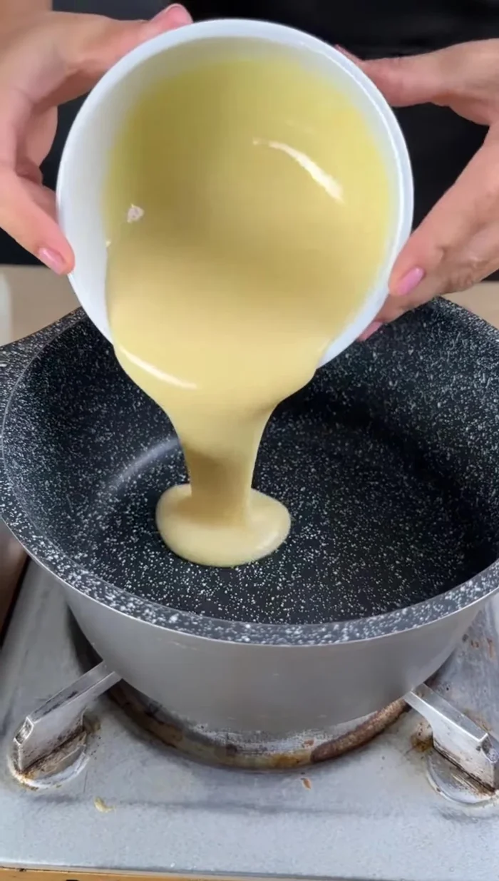 Dans une casserole, mélanger 100g de lait concentré, 4 jaunes d'œufs et 150g de fécule de maïs jusqu'à ce que la fécule soit dissoute.
