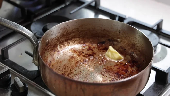 Délayer et réduire : Ajouter l'ail au bouillon. Déglacer la poêle où l'agneau a cuit avec le vin blanc, puis incorporer le bouillon épaissi.