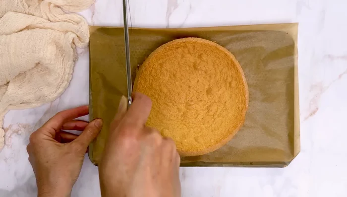 Démouler la génoise et la couper en deux. Une fois la crème pâtissière bien froide (température ambiante), ajouter le beurre pommade progressivement à vitesse moyenne. Laisser tourner 5 minutes jusqu'à ce que la crème soit bien légère et foisonnée.