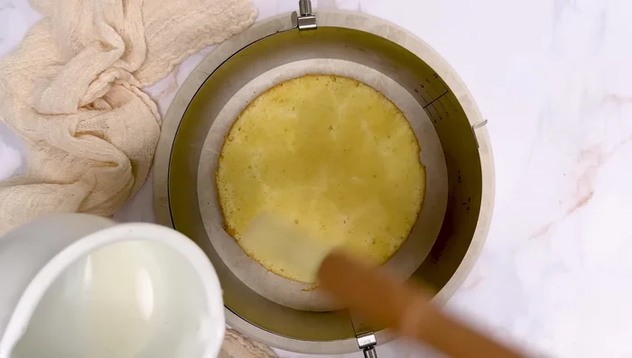 Montage du fraisier : Placer un premier disque de génoise imbibé de sirop au centre d'un cercle ajustable (20 cm). Ajouter des demi-fraises tout autour et des morceaux de fraises pour recouvrir entièrement. Remplir les trous avec la crème mousseline à la poche à douille. Ajouter une nouvelle couche de fraises, puis de crème. Recouvrir avec le deuxième disque de génoise imbibé. Ajouter une fine couche de crème et lisser.