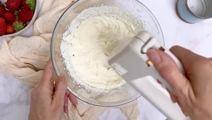 Décoration : Retirer le rodoïde. Faire une chantilly (fouetter la crème liquide entière jusqu'à épaississement, ajouter le sucre). Placer la chantilly dans une poche à douille et pocher autour du gâteau. Ajouter des fraises au centre et des feuilles de menthe ou basilic pour la décoration.