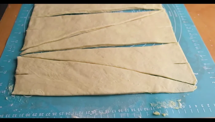 Faire une petite entaille à la base de chaque triangle et rouler lentement. Aplatir légèrement la dernière partie pour sceller. Répéter avec le reste de la pâte.