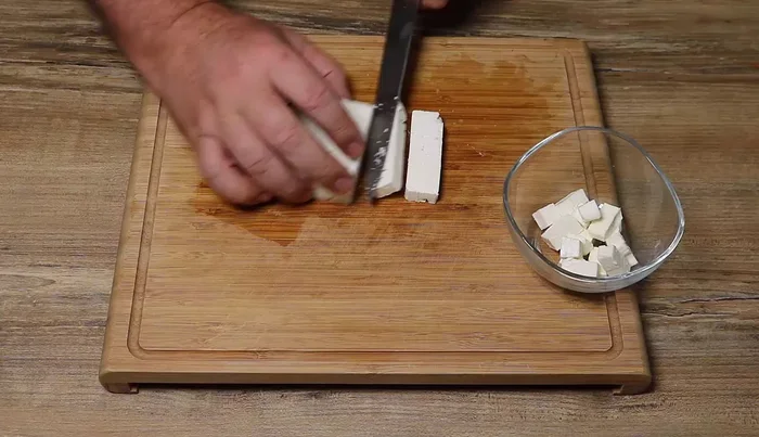 Couper la feta en bandes d'environ 1 cm d'épaisseur, puis en petits cubes.
