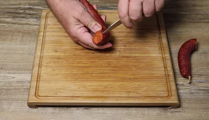 Retirer la peau du chorizo à l'aide d'un couteau bien affuté. Découper le chorizo en tranches épaisses, puis en petits cubes.