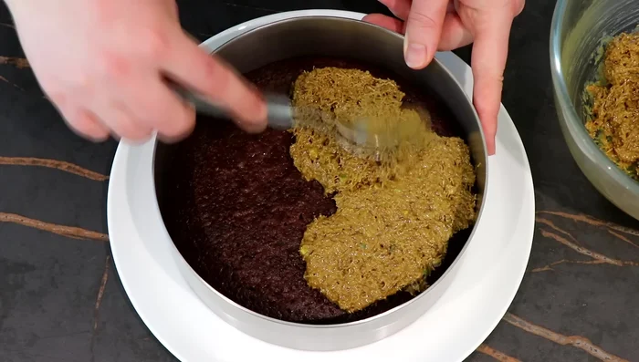 Étaler le croustillant sur le biscuit imbibé.