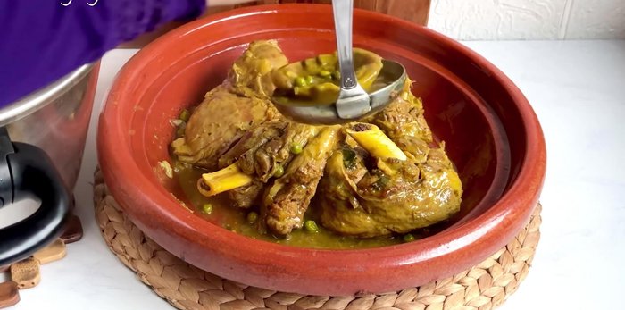 Dresser le tajine en disposant la viande, les cœurs d'artichauts, les petits pois et la sauce.