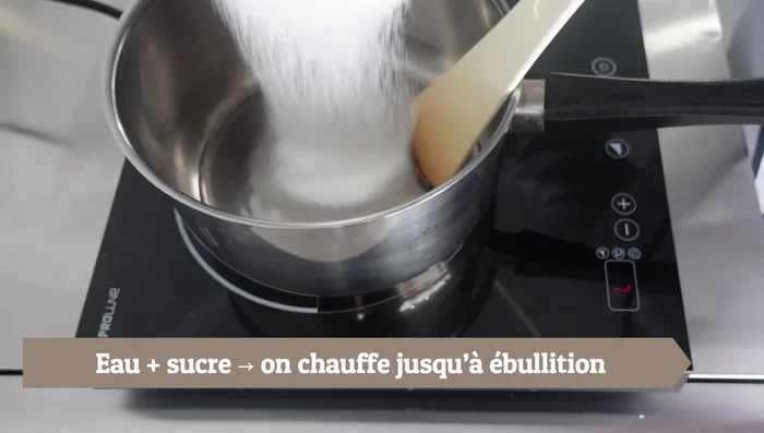 Ajouter l'eau dans la casserole, verser le sucre et chauffer jusqu'à ébullition.