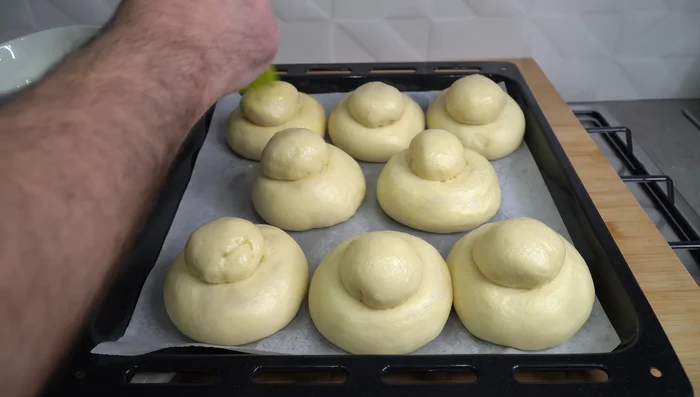 Mélanger un jaune d'œuf avec deux cuillères à soupe de lait. Badigeonner délicatement les brioches avec ce mélange. (533.8)